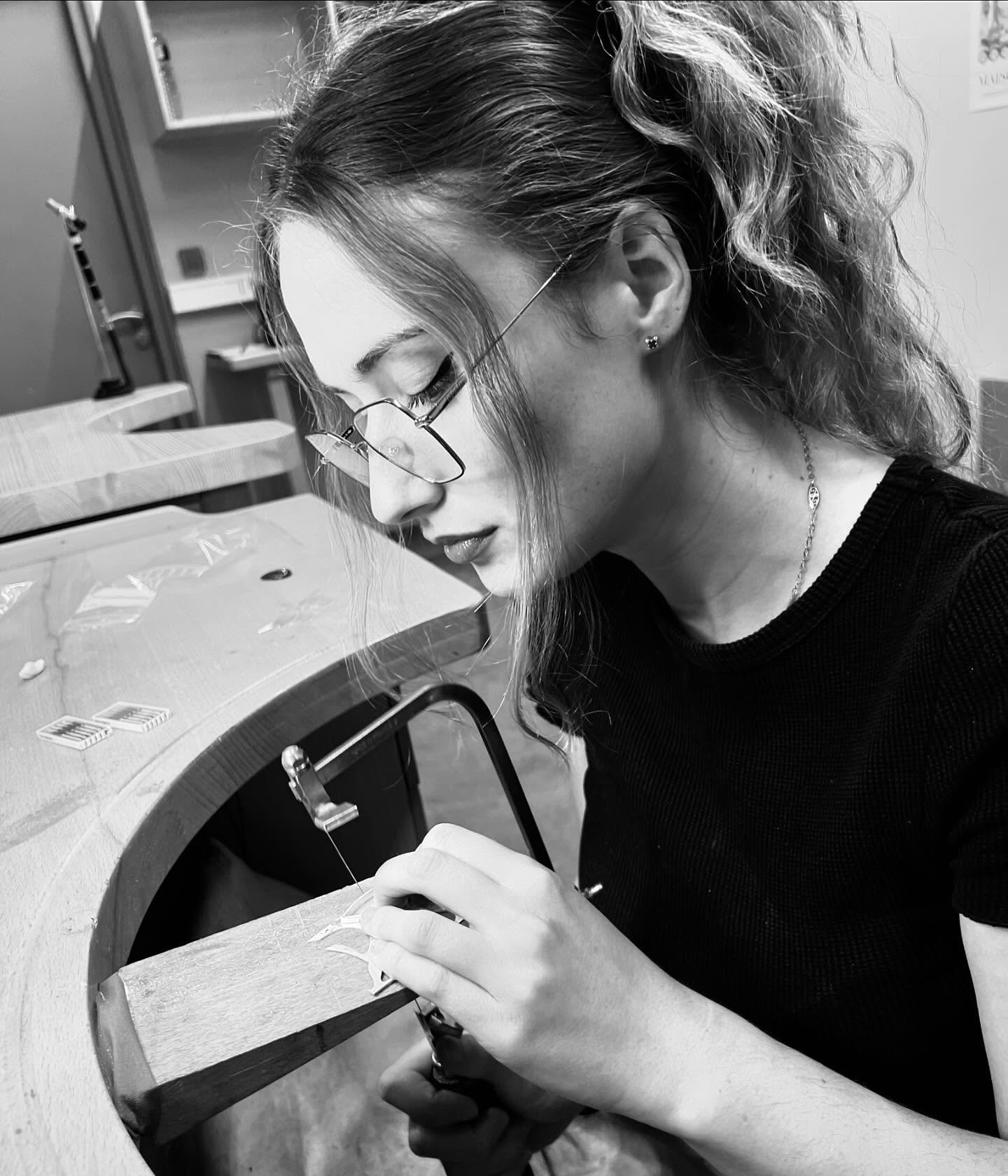 Pauline Billard perce une pièce d’argent à son établi, en noir et blanc